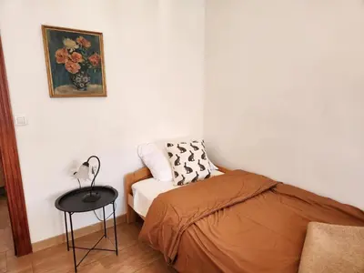 a small bedroom with a bed and a table at Apartmaji Boka in Bovec