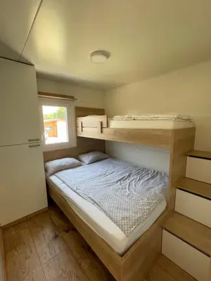 a small bedroom with a bed and two bunk beds at Pavel 1 Cottage with 2 Thermal Riviera Tickets in Moravske Toplice