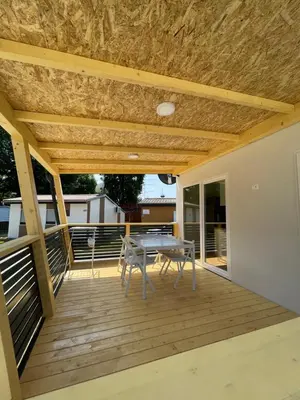 a patio with a table and chairs on a deck at Pavel 1 Cottage with 2 Thermal Riviera Tickets in Moravske Toplice