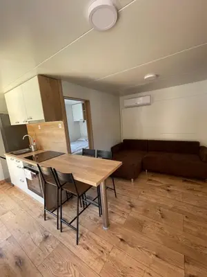 a kitchen and living room with a table and a couch at Pavel 1 Cottage with 2 Thermal Riviera Tickets in Moravske Toplice