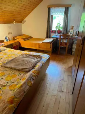 a bedroom with a bed and a desk and a table at Apartma Pri Tavčarju in Poljane nad Škofjo Loko