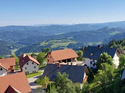 a village with houses and mountains in the background at Apartma Pri Tavčarju in Poljane nad Škofjo Loko