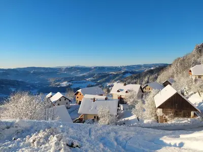 a village covered in snow on a mountain at Apartma Pri Tavčarju in Poljane nad Škofjo Loko