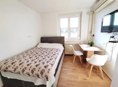 a small bedroom with a bed and a desk at Apartment Twin 1 in Ljubljana