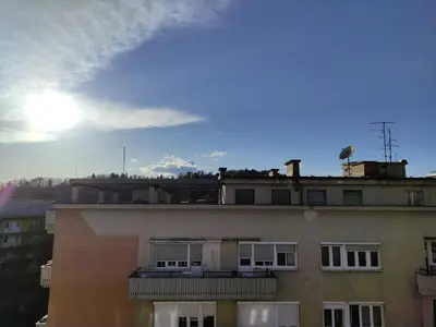 a view of a building with the sun in the sky at Apartment Twin 1 in Ljubljana