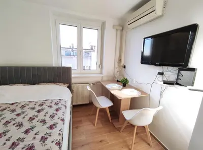 a bedroom with a bed and a desk and a tv at Apartment Twin 1 in Ljubljana