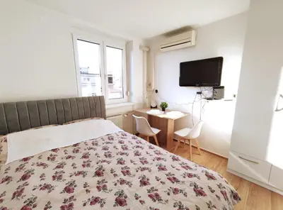 a bedroom with a bed and a desk and a tv at Apartment Twin 1 in Ljubljana