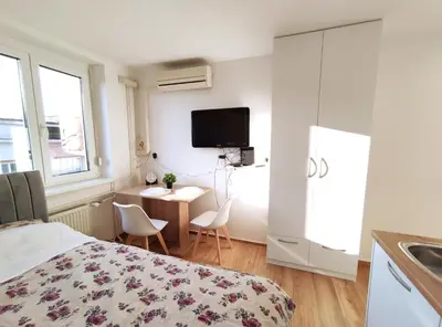 a bedroom with a bed and a table and a tv at Apartment Twin 1 in Ljubljana