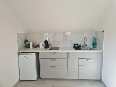 a white kitchen with a sink and a refrigerator at Linden Retreat Apartments with Sauna in Spodnje Mestinje