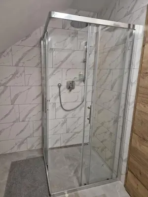 a shower with a glass door in a bathroom at Linden Retreat Apartments with Sauna in Spodnje Mestinje