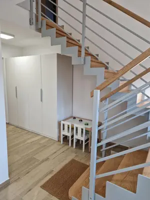 a staircase in a room with a table and a cabinet at Linden Retreat Apartments with Sauna in Spodnje Mestinje