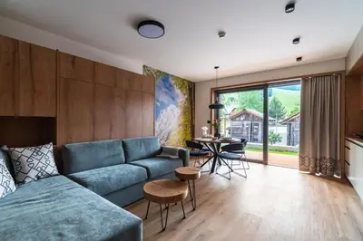 a living room with a blue couch and a table at Gora Luxury Apartments in Kranjska Gora