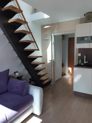 a staircase in a living room with a purple couch at Apartma Misha in Bovec