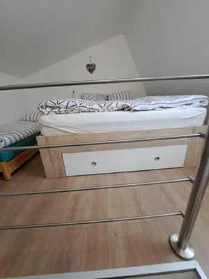 a bed in a room with a wooden floor at Apartma Misha in Bovec