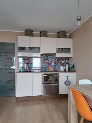 a kitchen with white cabinets and a table at Apartma Misha in Bovec