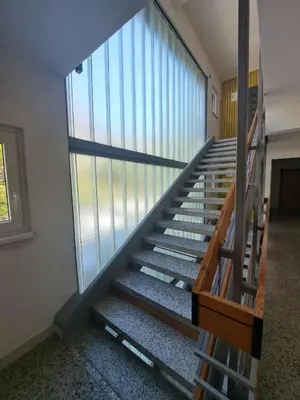 a staircase in a building with a large window at Apartma Misha in Bovec