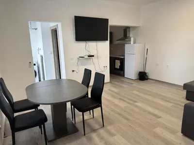 a dining room with a table and chairs and a kitchen at Jack apartments in Maribor