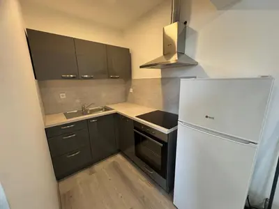 a small kitchen with a refrigerator and a sink at Jack apartments in Maribor