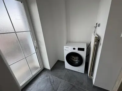 a laundry room with a washing machine and a shower at Jack apartments in Maribor