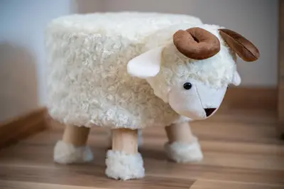 a stuffed animal of a sheep on a wooden floor at Apartment By The Forest in Zgornje Gorje