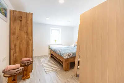 a bedroom with a bed and a large wooden door at Apartment By The Forest in Zgornje Gorje