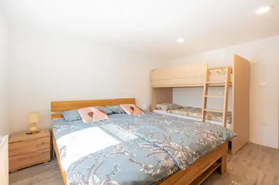 a bedroom with a bed and a bunk bed at Apartment By The Forest in Zgornje Gorje