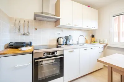 a kitchen with white cabinets and a stove top oven at Apartment By The Forest in Zgornje Gorje