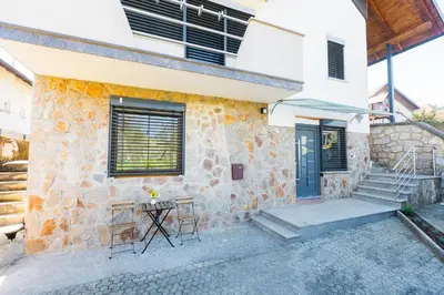 a stone house with a table and chairs in front of it at Apartma Tom in Metlika