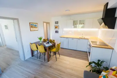 a kitchen and dining room with a table and chairs at Apartma Tom in Metlika