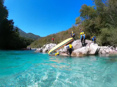 a group of people with a surfboard in the water at Holiday Home Kristi in Bovec