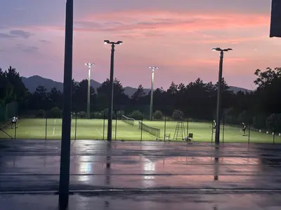 an empty parking lot with a park with a playground at Kamp Tura- camping pitch only in Vipava