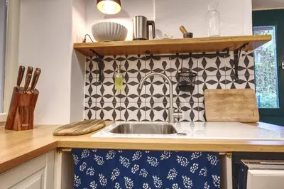 a kitchen sink with a black and white tile wall at Apartment Econte near old town in Ljubljana