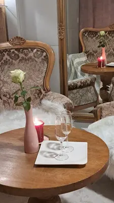 a table with two glasses and a vase with a rose at Mobile Home Cabana with HotTub&Sauna in Spodnja Polskava
