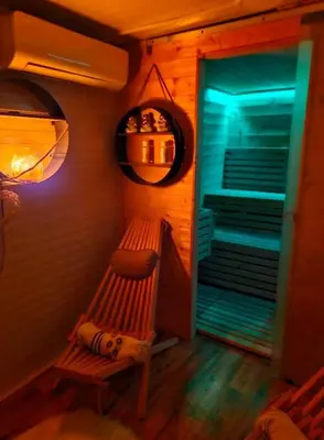 a wooden bench in a room with a blue light at Mobile Home Cabana with HotTub&Sauna in Spodnja Polskava