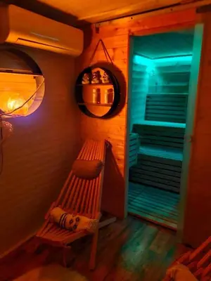 a wooden bench in a room with a blue light at Mobile Home Cabana with HotTub&Sauna in Spodnja Polskava
