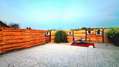 a wooden fence with two chairs in front of it at Mobile Home Cabana with HotTub&Sauna in Spodnja Polskava