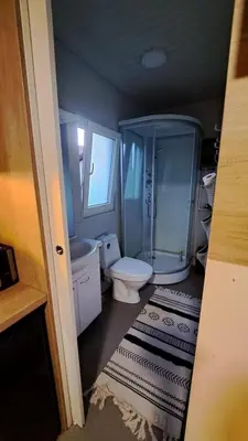 a small bathroom with a toilet and a shower at Mobile Home Cabana with HotTub&Sauna in Spodnja Polskava