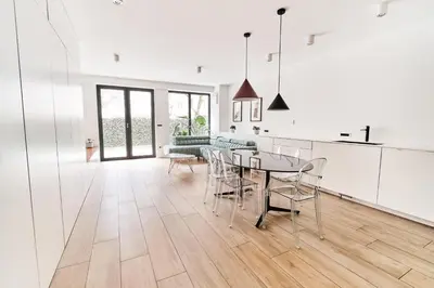 a kitchen and living room with a table and chairs at Matic Atrium Designer Apartment in Ljubljana