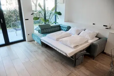 a couch sitting in a living room with a couch at Matic Atrium Designer Apartment in Ljubljana