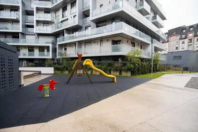 a playground in front of a apartment building at Matic Atrium Designer Apartment in Ljubljana