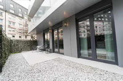 a building with large windows and a patio at Matic Atrium Designer Apartment in Ljubljana