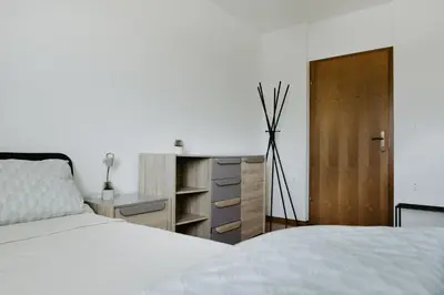 a bedroom with a white bed and a wooden door at Inspired by Nature Homestay