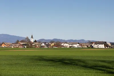 a large field of green grass with a town in the background at Inspired by Nature Homestay