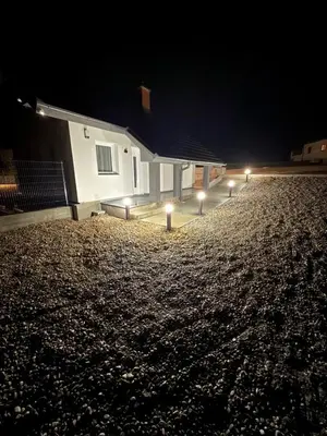 a house with lights in front of it at night at Resort PJagodic in Cerklje na Gorenjskem