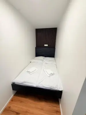 a small bed in a room with white walls at Resort PJagodic in Cerklje na Gorenjskem