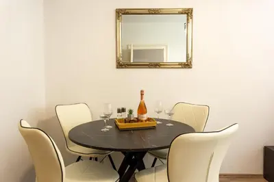 a dining room table with a bottle of wine and a mirror at Old Town Sixteen in Ljubljana