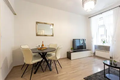 a dining room with a table and chairs and a tv at Old Town Sixteen in Ljubljana