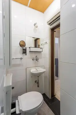 a white bathroom with a toilet and a sink at Old Town Sixteen in Ljubljana