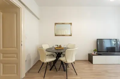 a dining room with a table and white chairs at Old Town Sixteen in Ljubljana