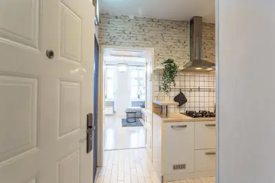 a kitchen with a door open to a kitchen with white cabinets at Old Town Sixteen in Ljubljana